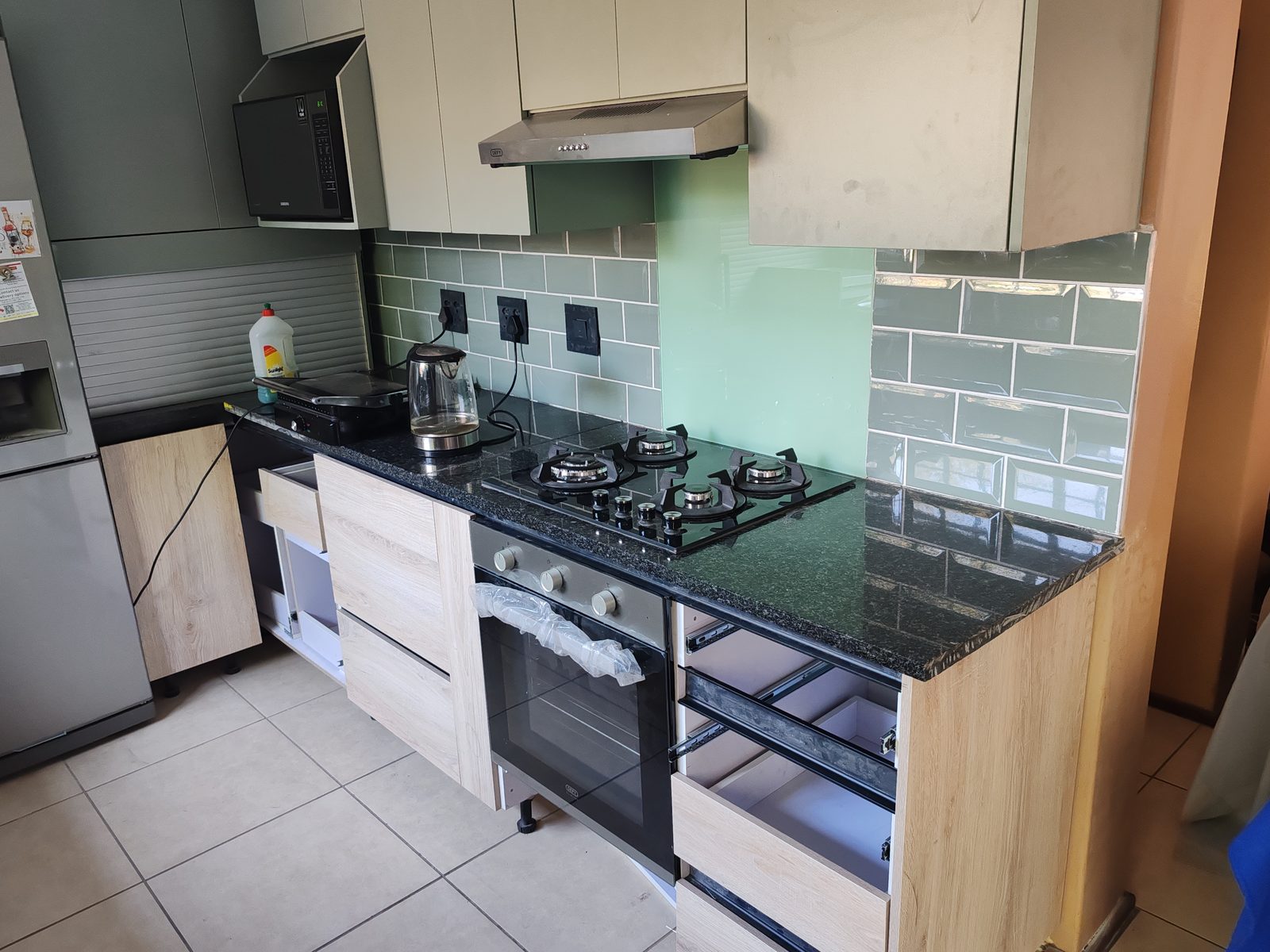 Completed kitchen gas hob installation with cabinetry and countertop