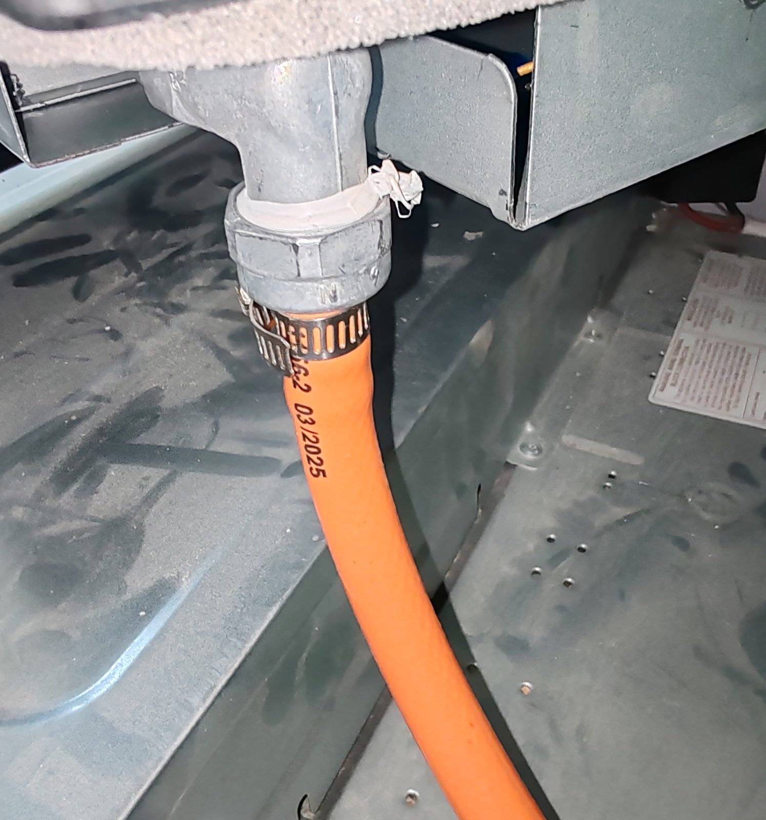 Close-up of orange gas hose connection to appliance